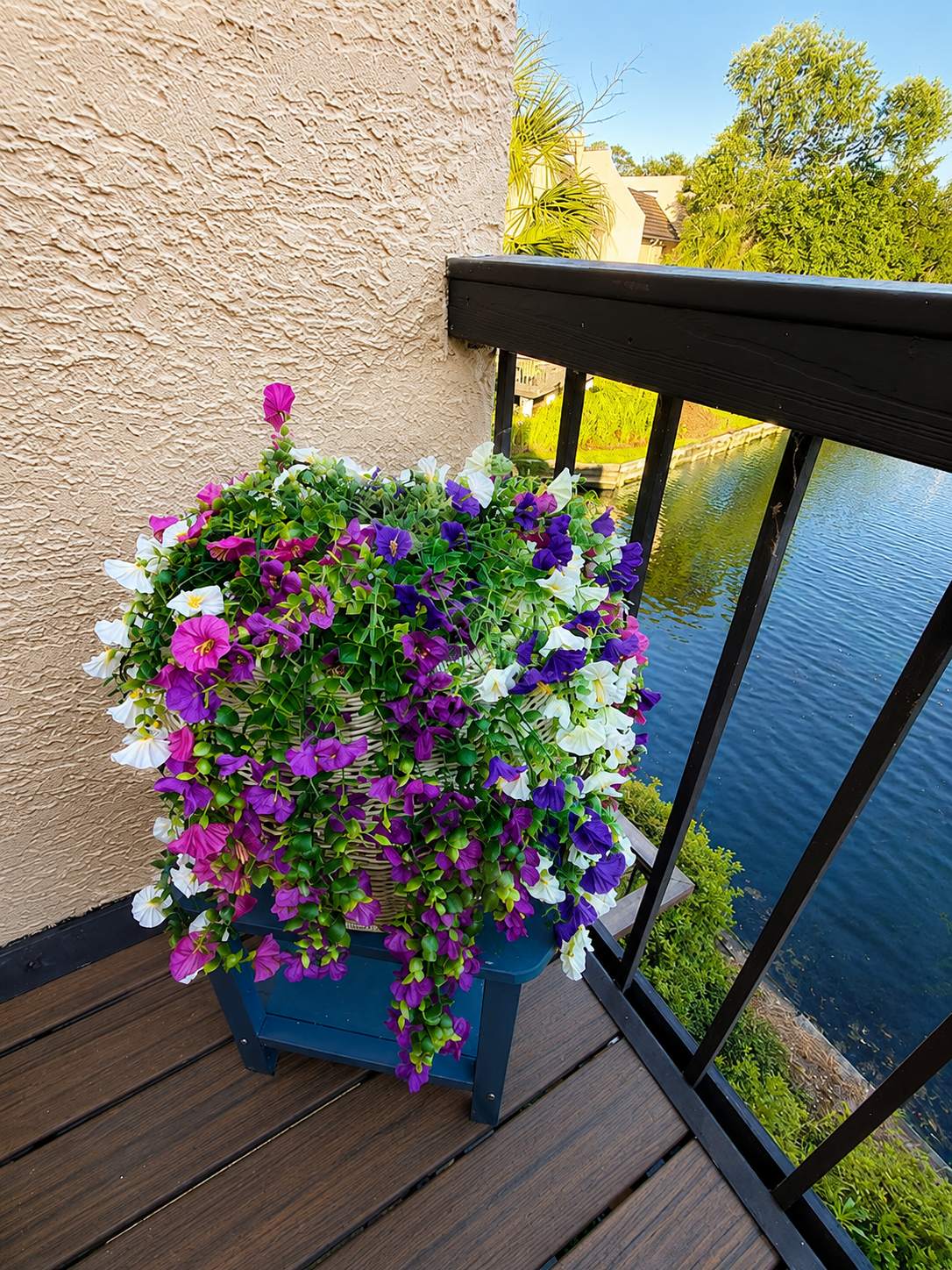 Balcony planter with colorful blooms over the water