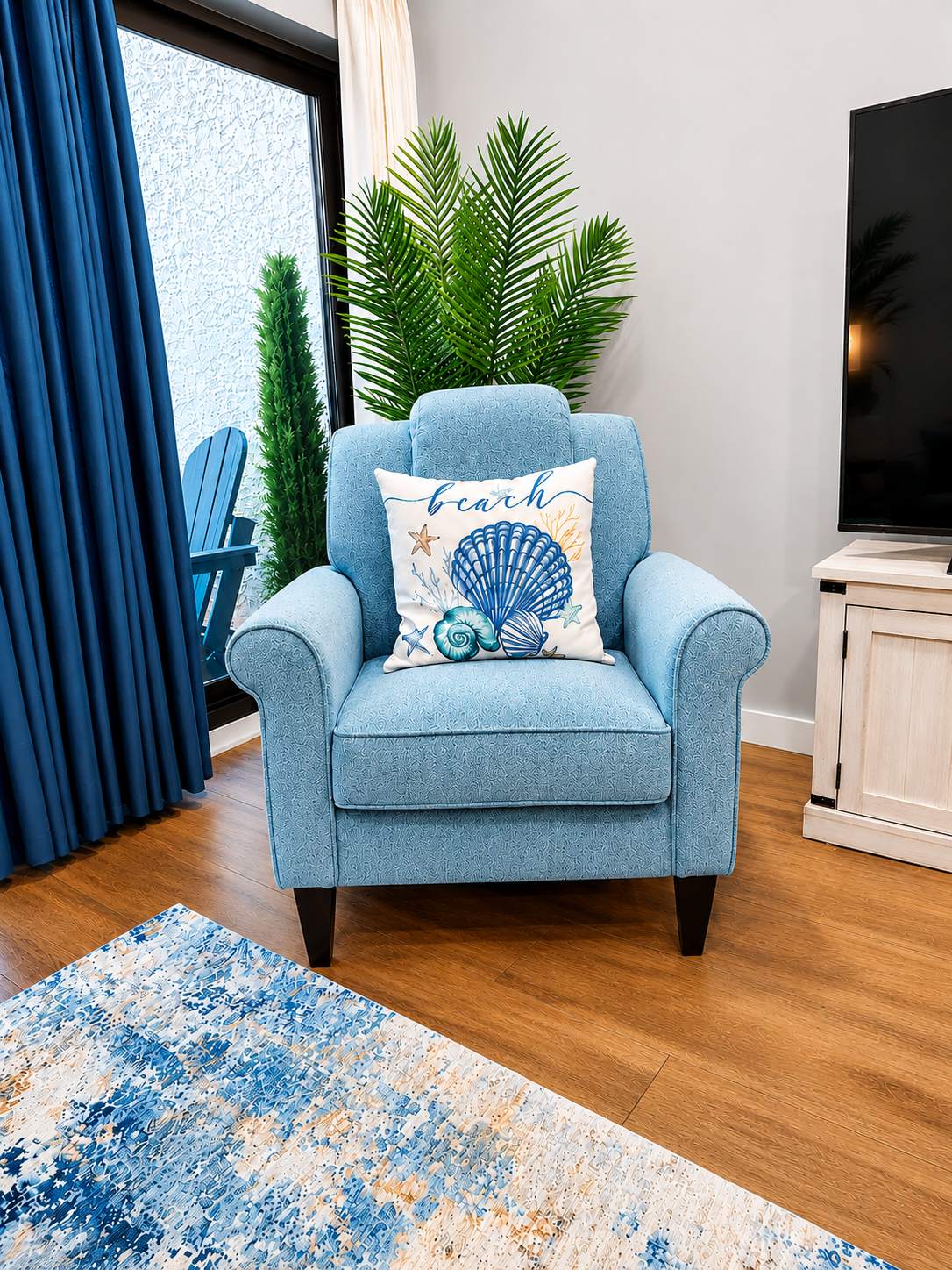 Reading nook with plush blue armchair by the balcony door